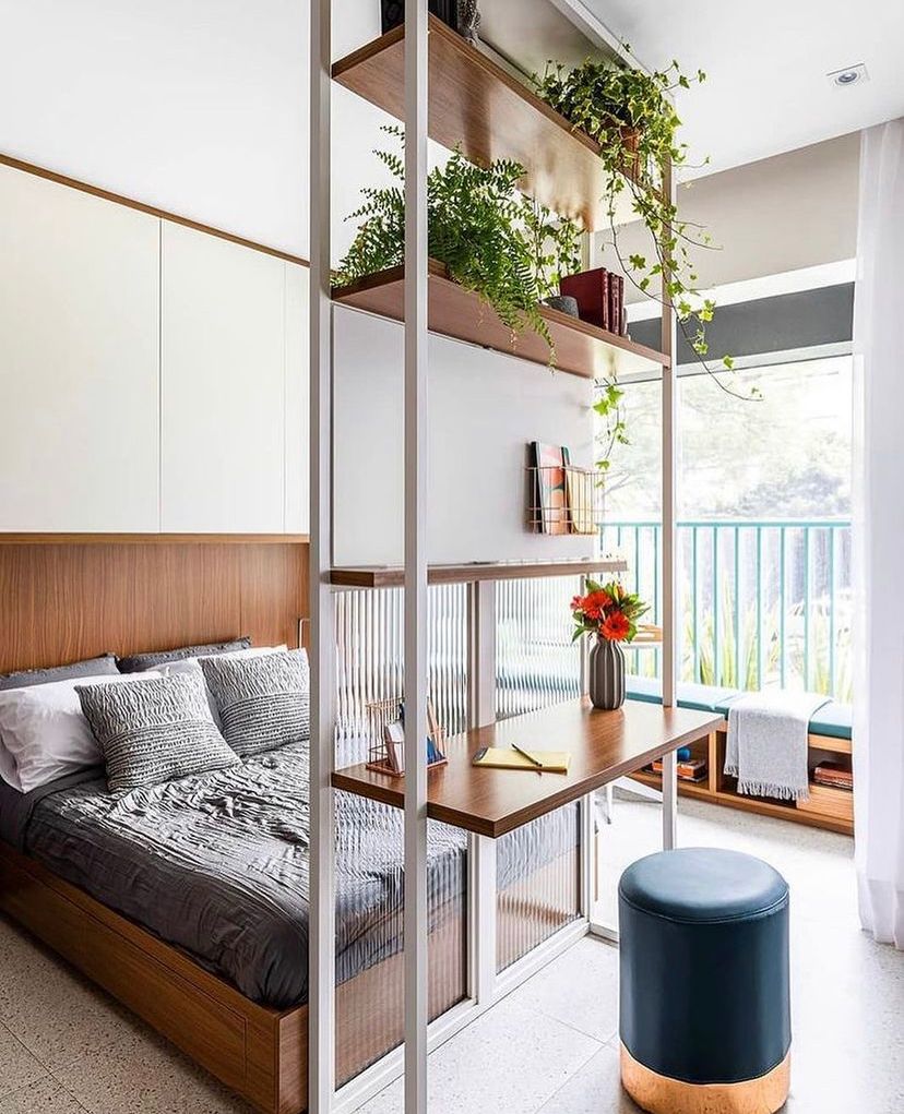 Projeto Liberdade: Dormitório com cama de madeira, divisória vazada com escrivaninha e plantas junto à varanda.