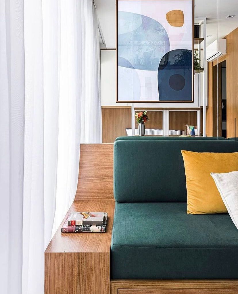Projeto Liberdade: Sala com sofá verde, painel de madeira e estante integrada.
