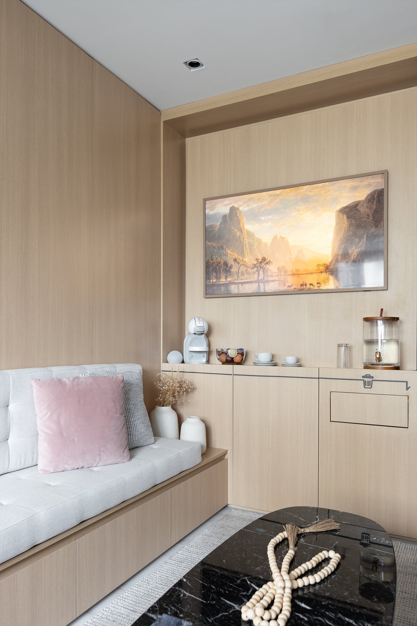 Projeto Moema: Sofá claro com painel de madeira, quadro e armário integrado.