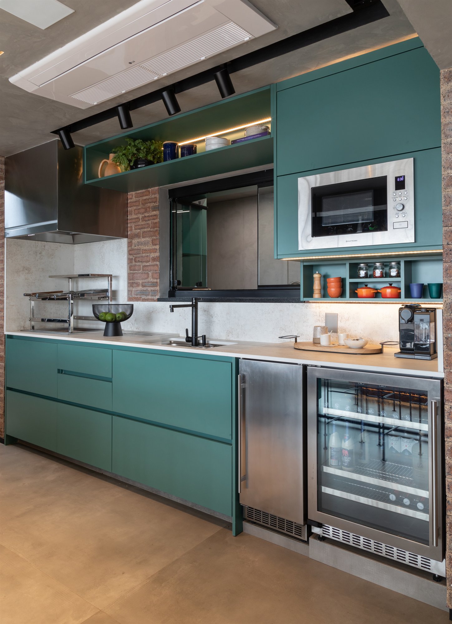 Projeto Mooca: Cozinha planejada com marcenaria verde petróleo e eletrodomésticos integrados.