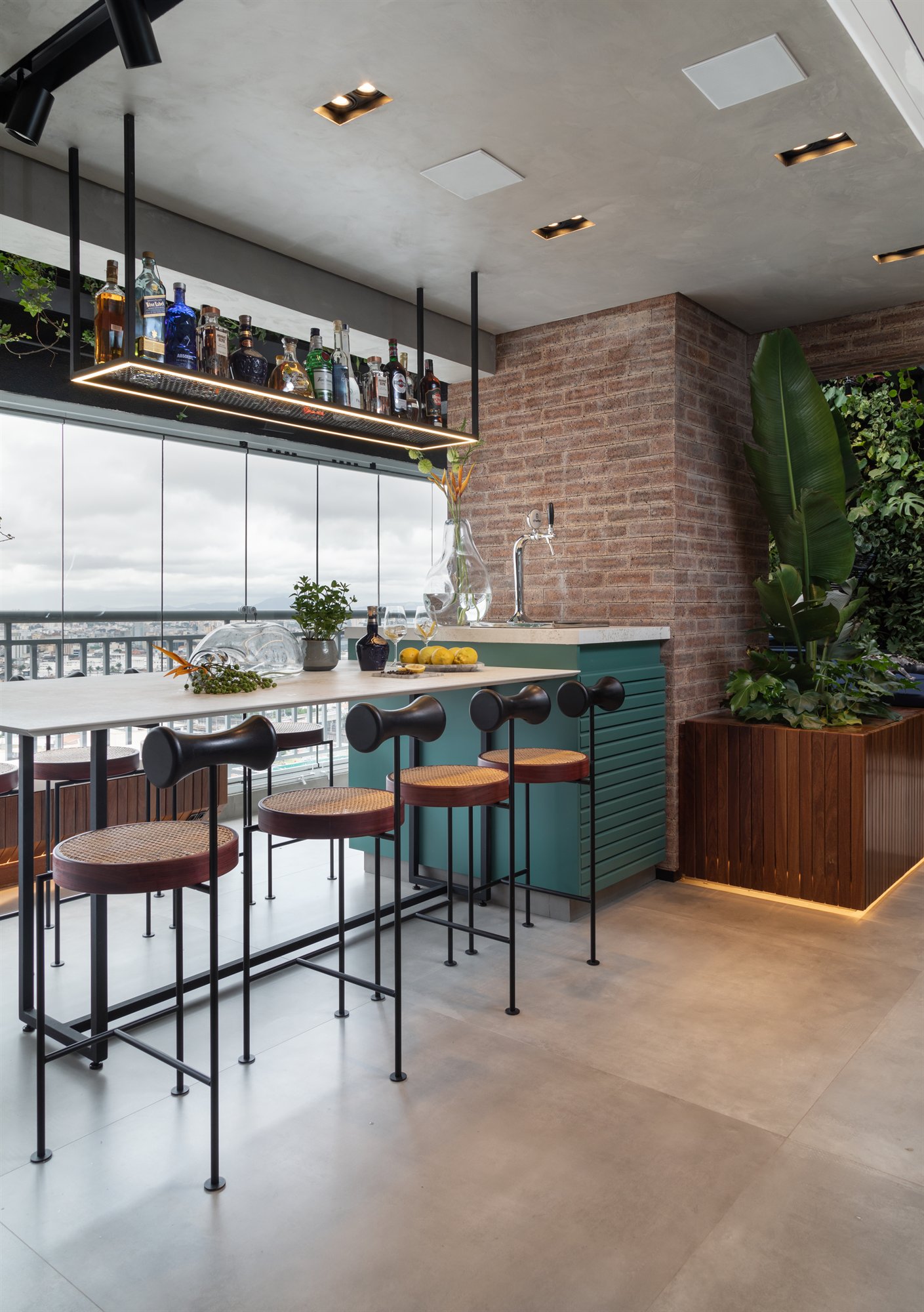 Projeto Mooca: Cozinha e espaço gourmet integrados à varanda, com ilha verde e banquetas.
