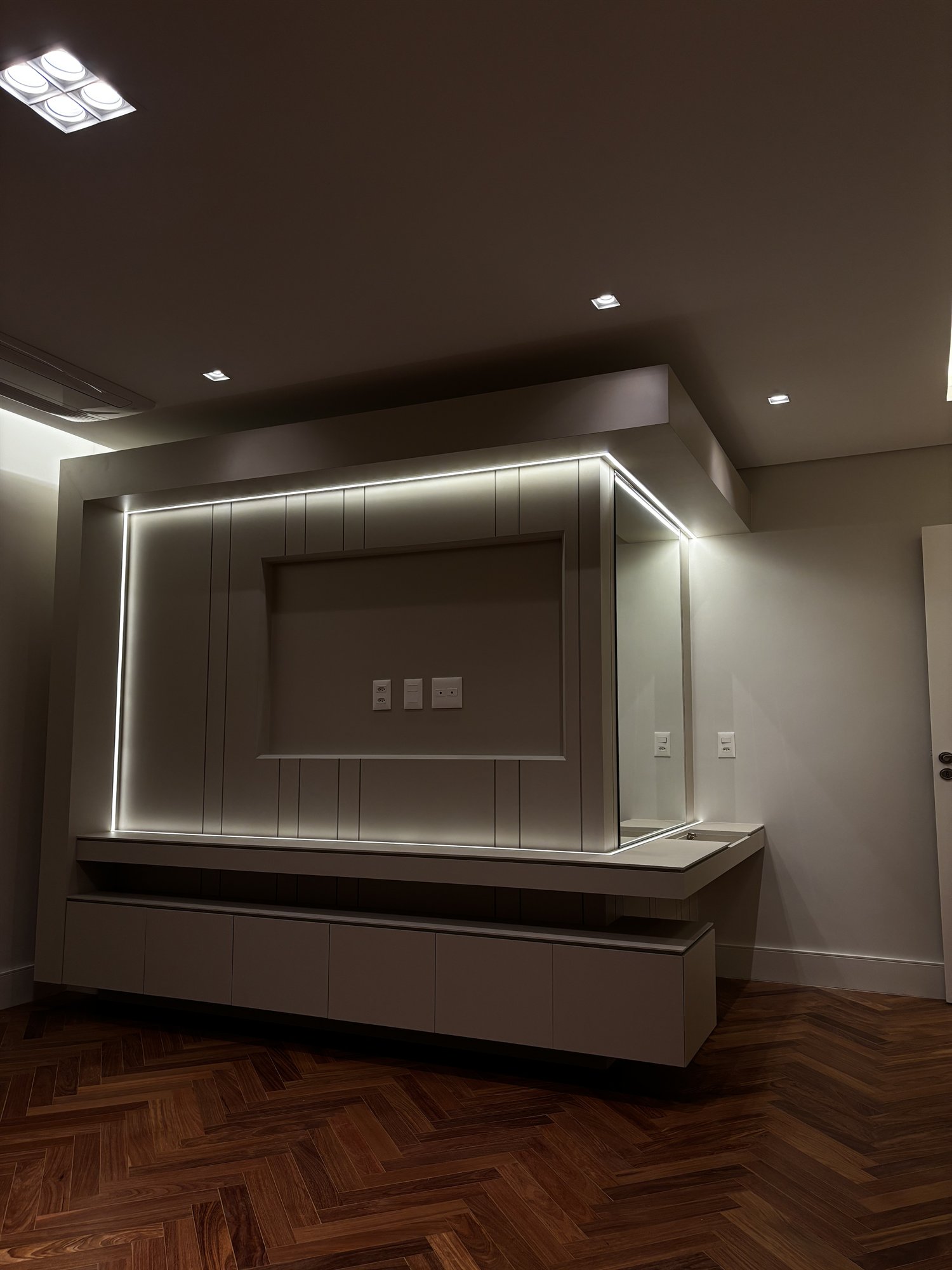 Projeto Perdizes: Outra vista do painel de TV e bancada flutuante com iluminação indireta.