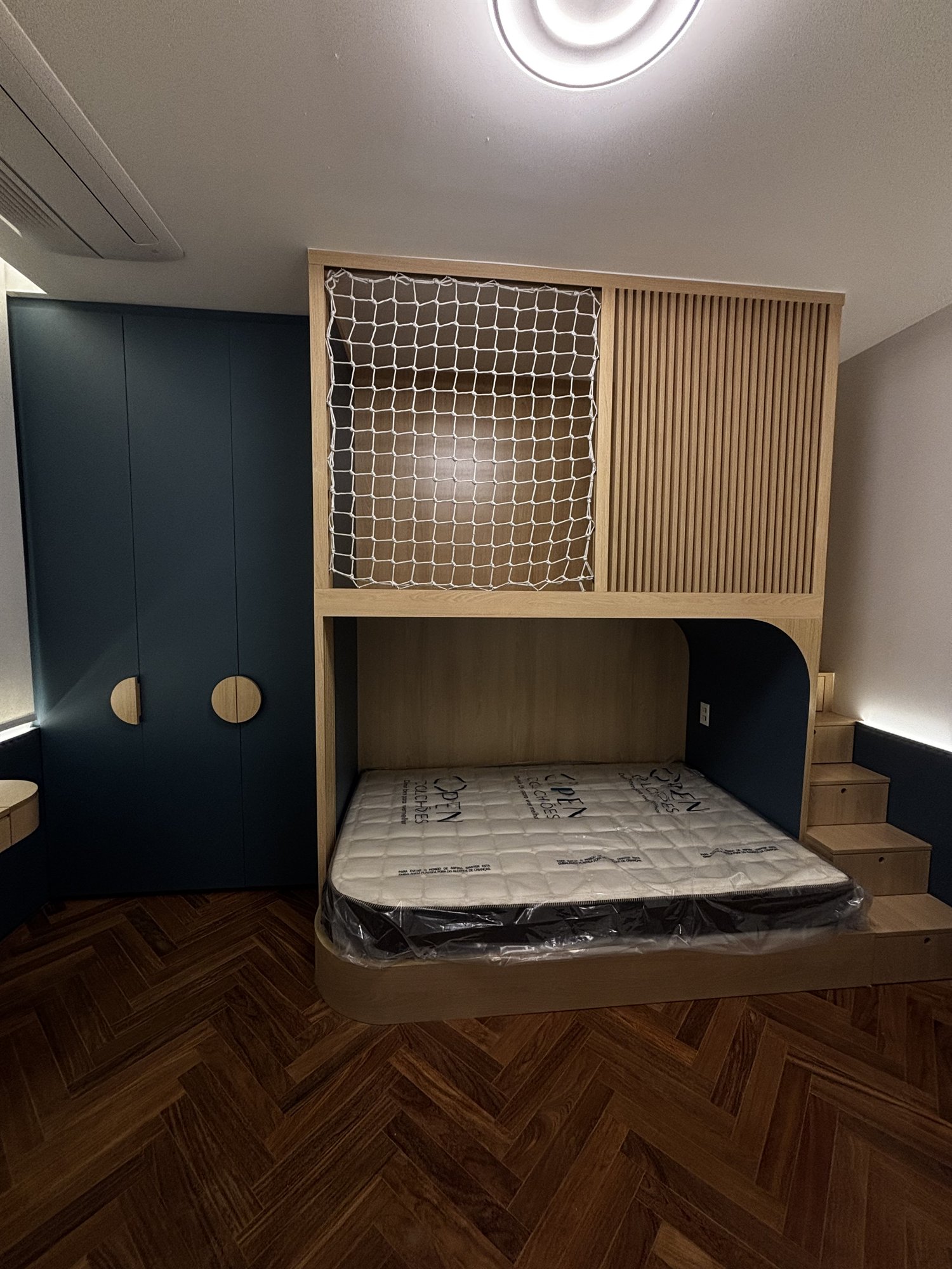 Projeto Perdizes: Quarto compacto com cama integrada, armário superior vazado e cabeceira azul.