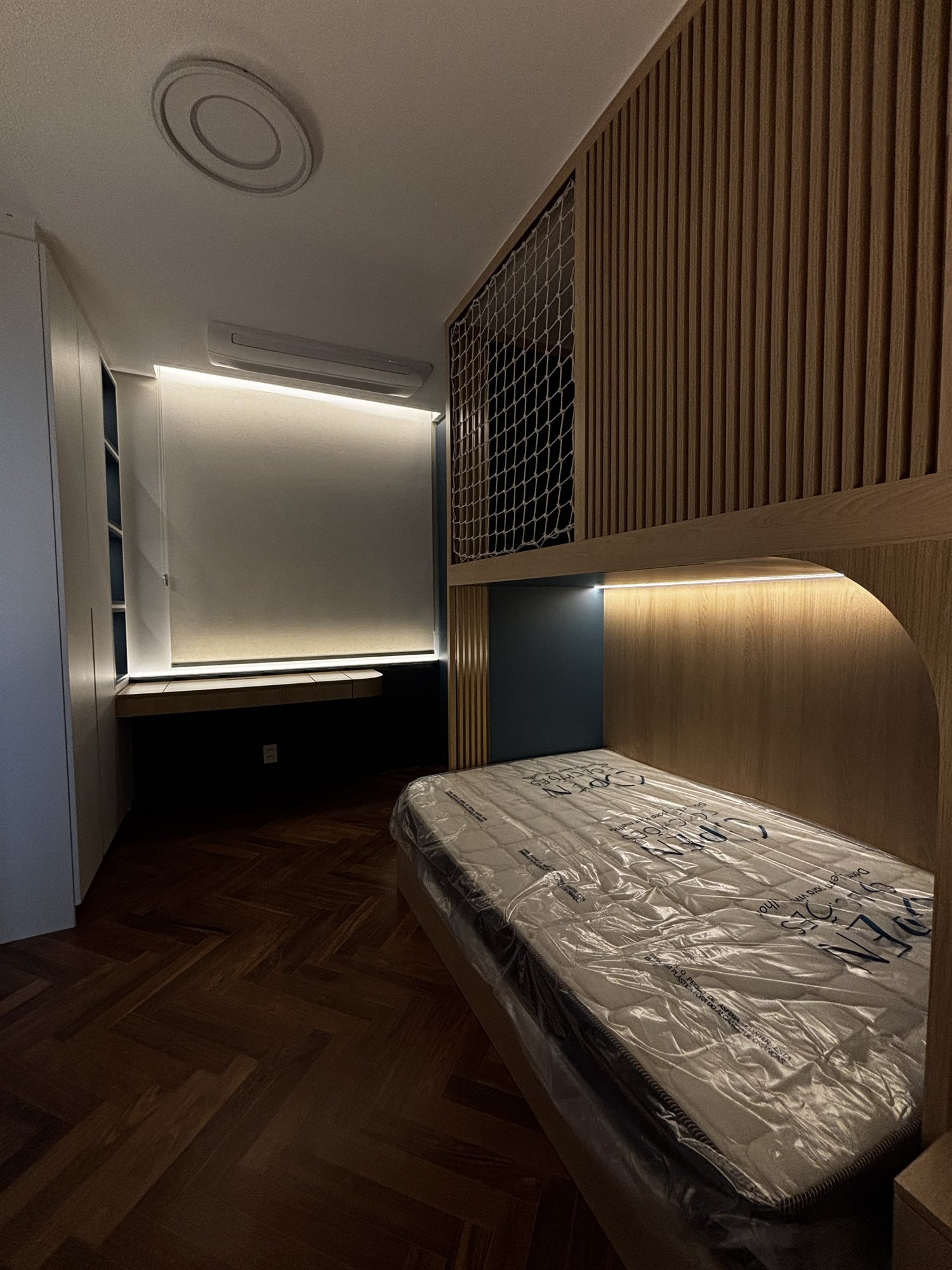 Projeto Perdizes: Dormitório compacto com cama embutida, painel ripado e iluminação indireta.