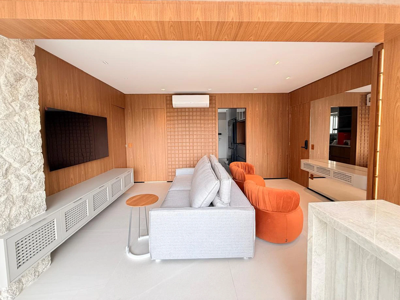 Sala em Santo Amaro com painel e marcenaria em madeira
