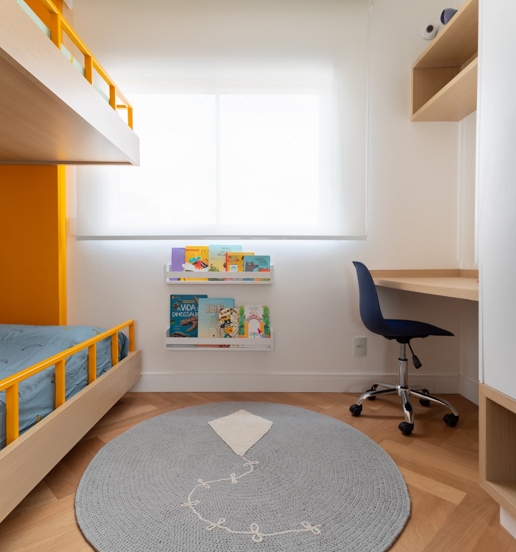 Projeto Vila Olimpia: Dormitório infantil com cama alta, bancada de estudos e parede laranja.